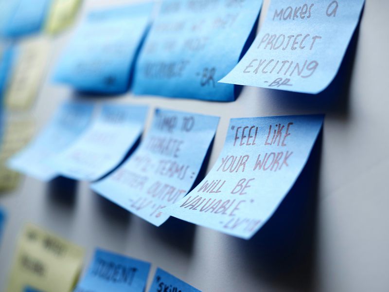 Wall of handwritten sticky notes with student feedback, including “makes a project exciting” and “feel like your work will be valuable”